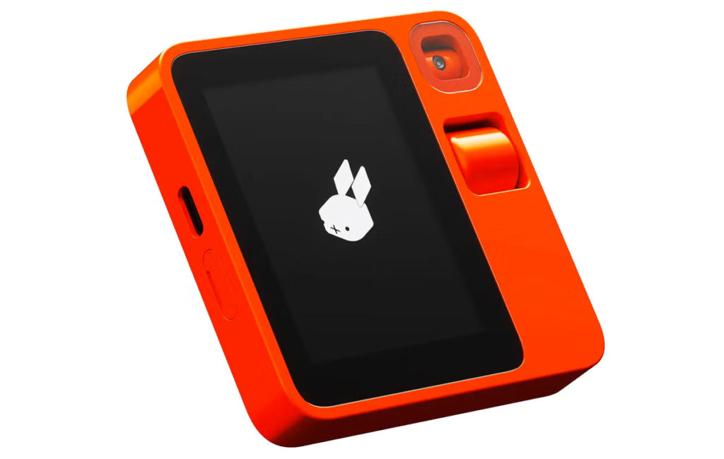 Appareil photo compact orange avec un écran noir affichant un logo de lapin blanc, accompagné d'une molette et d'une caméra intégrée.