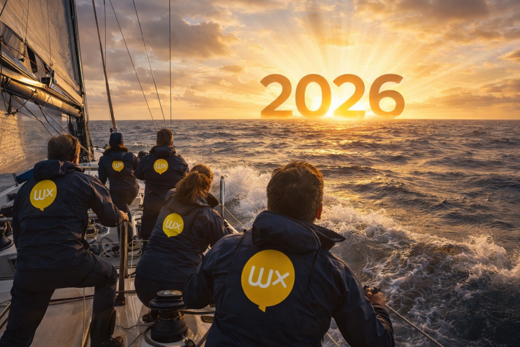 Une équipe mixte de marins, vêtue de tenues bleu foncé, manœuvre avec calme et coordination à bord d’un voilier moderne de compétition avançant sur une mer houleuse. À l’horizon, un immense « 2026 » baigné de lumière dorée émerge sous les rayons du soleil levant, symbolisant l’avenir vers lequel l’équipage se dirige avec confiance.