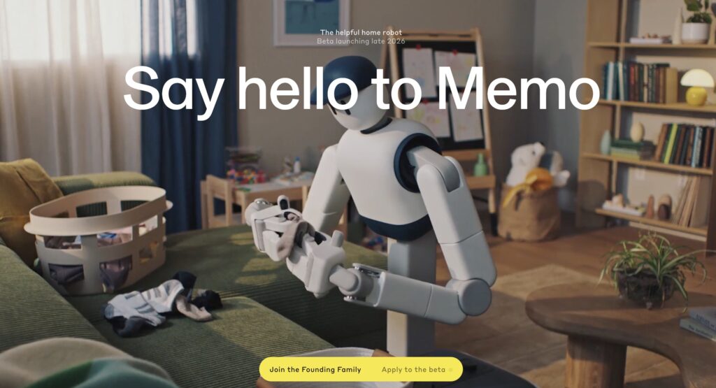Robot humanoïde domestique nommé Memo en train de plier du linge dans un salon familial, avec jouets d’enfants et étagères en arrière-plan, illustrant un assistant robotique pour la maison. Texte à l’écran : « Say hello to Memo ».